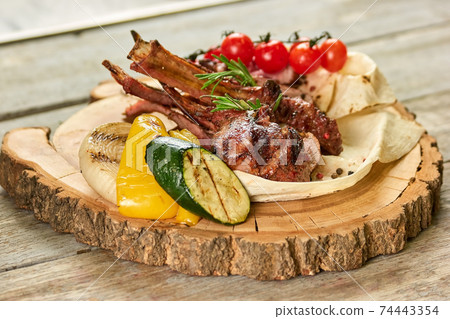 Lamb shrank with side dish on wooden plate. 74443354