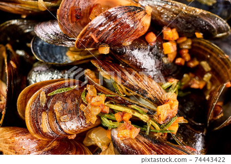 Closeup macro cooked mussels with chopped vegetables. 74443422