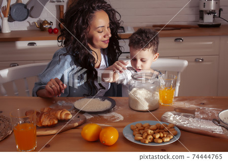young pretty african american mother with little cute son on kitchen in morning preparing breakfast, lifestyle people concept young pretty african american mother with little cute son on kitchen in morning preparing breakfast, lifestyle people concept 74444765