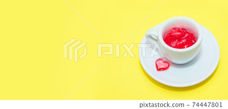cup with hearts on a red background. the view from the top. red hearts spilled out. isolated on a pink background. copy space. panton 74447801