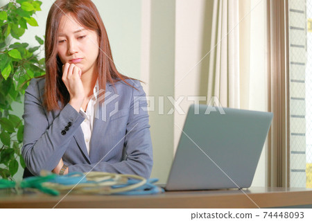 A woman who looks at the stacked LAN cables and thinks A woman who looks at the stacked LAN cables and thinks 74448093
