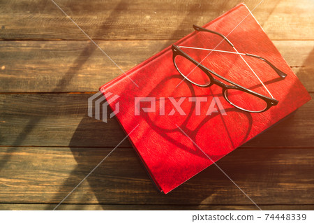 Reading glasses put on hardcover books 74448339