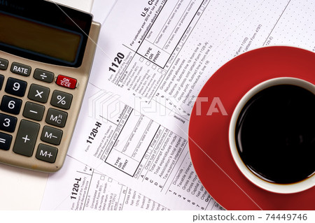1120 tax forms top view with coffee cup and calculator 1120 tax forms top view with coffee cup and calculator 74449746