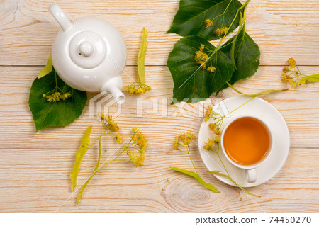 linden herbal tea with raw plant on wooden table linden herbal tea with raw plant on wooden table 74450270