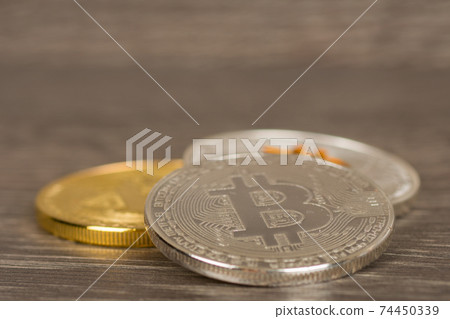 silver and golden mettallic cryptocurrency coins on wooden table silver and golden mettallic cryptocurrency coins on wooden table 74450339