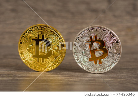silver and golden bitcoin mettallic coins on wooden table silver and golden bitcoin mettallic coins on wooden table 74450340
