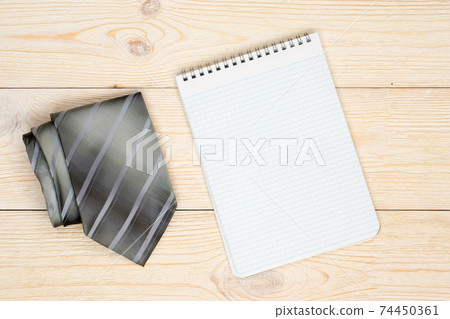 gray neck tie with empty paper sheet on workbench gray neck tie with empty paper sheet on workbench 74450361
