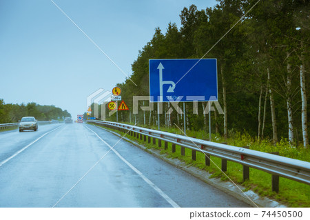 blank blue billboard with detour arrow directions and warning road signs near motorway blank blue billboard with detour arrow directions and warning road signs near motorway 74450500