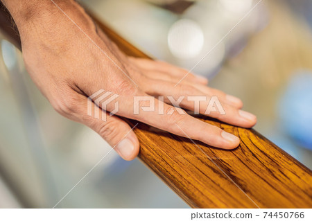 support, help and people concept - close up of man hand holding to railing support, help and people concept - close up of man hand holding to railing 74450766
