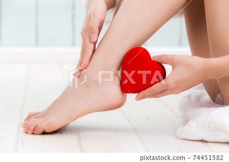 有心臟的一名婦女在她的腿。 74451582