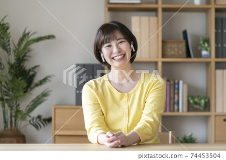 A young woman looking at the camera with wireless headphones 74453504