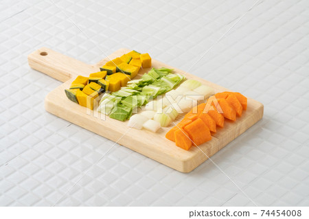 健康蔬菜的形像在切菜板上切蔬菜 74454008