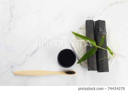 Activated Bamboo charcoal tooth powder on marble background. 74454270