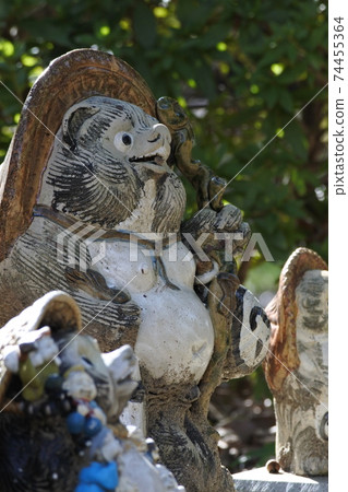 Shigaraki ware raccoon dog A raccoon dog with a big belly is standing with a smiling face. profile. Vertical photo. Shigaraki ware raccoon dog A raccoon dog with a big belly is standing with a smiling face. profile. Vertical photo. 74455364