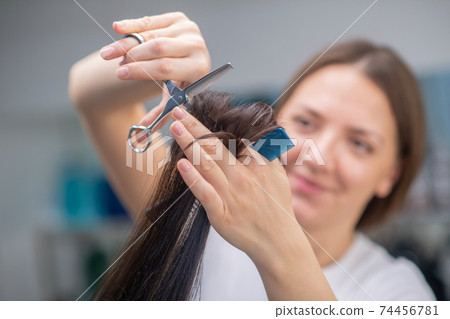 Female hairdresser doing a new haircut to her customer 74456781