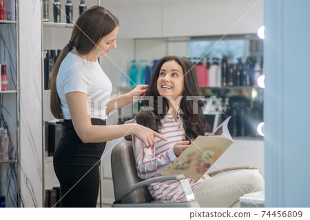 Dark-haired woman spending time in a hair salon Dark-haired woman spending time in a hair salon 74456809