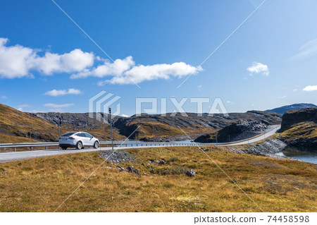 White car drive Norway highway mountain sunny day 74458598