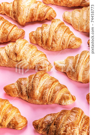 freshly baked croissants lie on a pink freshly baked croissants lie on a pink 74458773