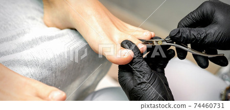 Pedicure master is cutting cuticle 74460731