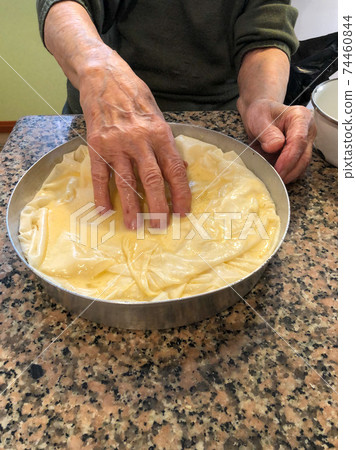 closeup wrinkled hands making dough pastry in the kitchen closeup wrinkled hands making dough pastry in the kitchen 74460844