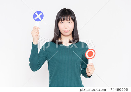 一個女人站在白牆前,舉著OK和NG標語牌 一個女人站在白牆前,舉著OK和NG標語牌 74460996