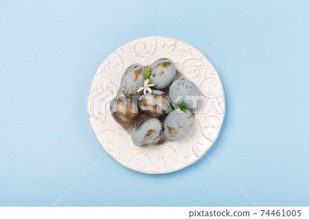 Easter Decoration with blue golden eggs, quail feathers, flowers on blue background. Happy Easter card concept. Easter Decoration with blue golden eggs, quail feathers, flowers on blue background. Happy Easter card concept. 74461005