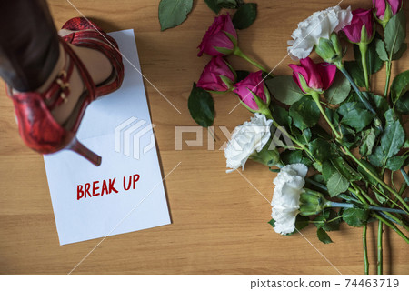 Paper with word break up on a floor with withered flowers. Heart broken. Divorce 74463719
