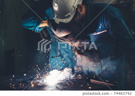 Skillful metal worker working with arc welding machine in factory Skillful metal worker working with arc welding machine in factory 74463742