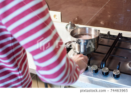 Man and boiling chicken breast in a saucepan Man and boiling chicken breast in a saucepan 74463965