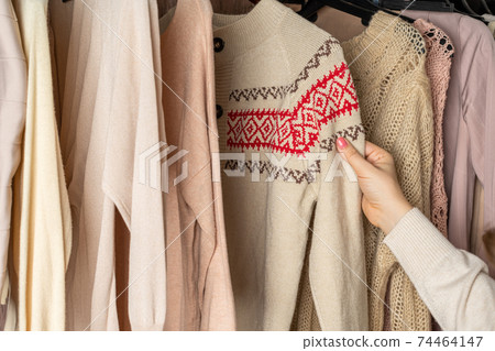 Woman choosing woolen sweater with christmas ornament in home cupboard. Season concept Woman choosing woolen sweater with christmas ornament in home cupboard. Season concept 74464147