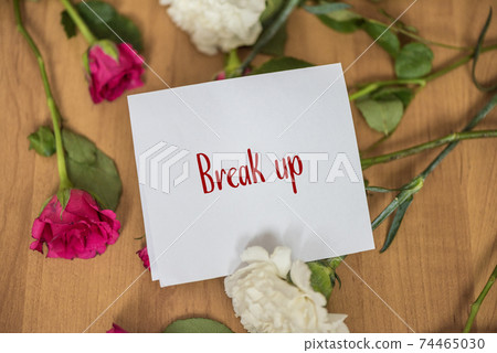 Paper with the end word on a floor with withered flowers. 74465030