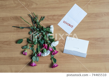Paper with divorce word on a floor with withered flowers. Concept. Paper with divorce word on a floor with withered flowers. Concept. 74465510