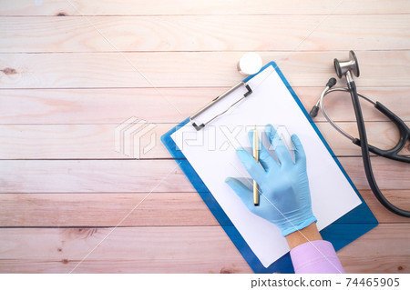 doctor hand in latex gloves writing prescription on desk, top view doctor hand in latex gloves writing prescription on desk, top view 74465905