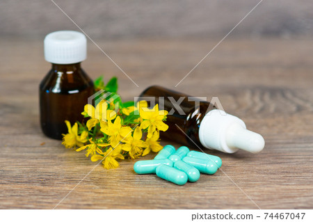 organic herbal medication in green capsules and brown glass bottles organic herbal medication in green capsules and brown glass bottles 74467047