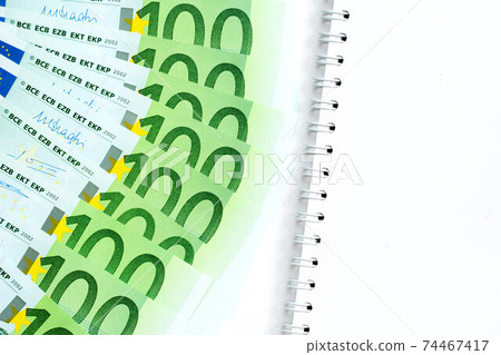 100 euro banknotes and empty notepad on white background 100 euro banknotes and empty notepad on white background 74467417