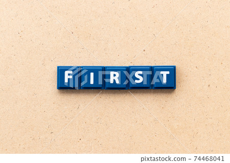 Tile alphabet letter in word first on wood background 74468041