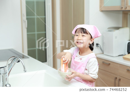5-year-old girl helping to wash dishes 74468252