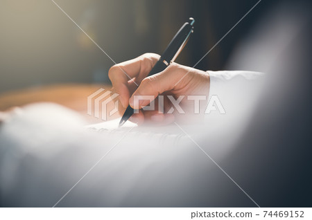People writing on notebook and work with paper on wooden table. 74469152