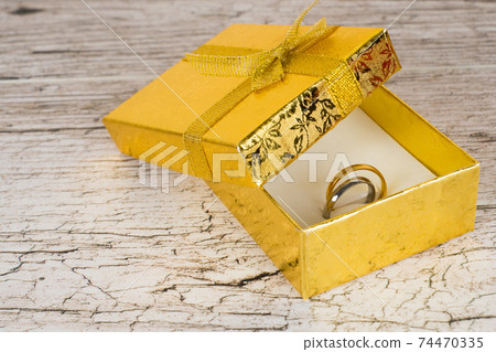 golden and silver pair rings in gift box on rustic wooden table golden and silver pair rings in gift box on rustic wooden table 74470335
