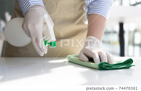 Close up Staff hand Restaurant workers are cleaning table and spraying disinfectants during the virus outbreak, Using cleaning solutions or using alcohol to kill germs in the restaurant. Close up Staff hand Restaurant workers are cleaning table and spraying disinfectants during the virus outbreak, Using cleaning solutions or using alcohol to kill germs in the restaurant. 74470381
