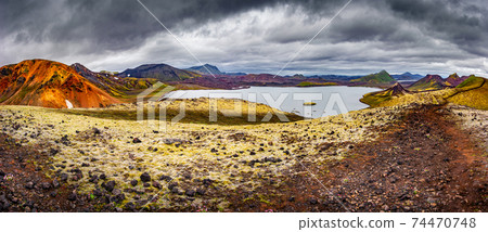 Panoramic landscape view of colorful rainbow volcanic Landmannalaugar mountains, volcanoes, lava fields, crater, water streams and lagoons at blue sky with clouds, Iceland, summer. 74470748