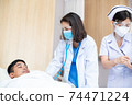 Asian doctor wearing mask and face shield with nurse using stethoscope checking health of patient man sleeping in bed at hospital ward. healthcare insurance during coronavirus. new normal concept 74471224