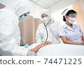 Emergency paramedic doctor in PPE suit and medical mask or face shield and female nurse having first aid check patient affect of Coronavirus or covid19 at hospital ward. healthcare concept 74471225