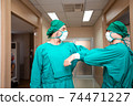 Portrait Caucasian surgeon doctor elbow bump greeting for social distancing with friend co-worker in hospital hallway. new normal etiquette concept during Coronavirus or Covid. Healthcare and medical 74471227