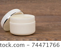 white opened plastic jar with body cream on wooden table 74471766