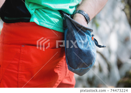 Close-up of a bag of magnesia hanging on a climber's belt in the forest on a trainer. pouch of magnesia Close-up of a bag of magnesia hanging on a climber's belt in the forest on a trainer. pouch of magnesia 74473224