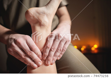 Close-up massage of legs and feet of a client in a massage parlor 74473238