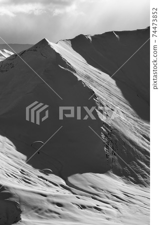 Speed riding in snowy sunlight mountains at winter evening Speed riding in snowy sunlight mountains at winter evening 74473852