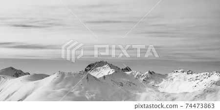 Panoramic view on snowy slope in high winter mountains and sunlit cloudy sky Panoramic view on snowy slope in high winter mountains and sunlit cloudy sky 74473863