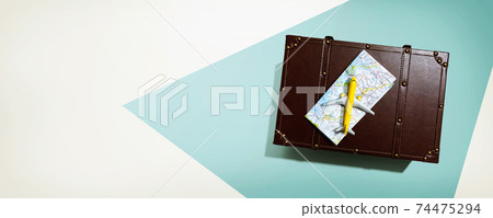 Travel theme with a miniature airplane and a suitcase Travel theme with a miniature airplane and a suitcase 74475294